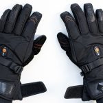 Photograph of ORORO Heated Gloves over motorcycle handlebars in a motorcycle garage